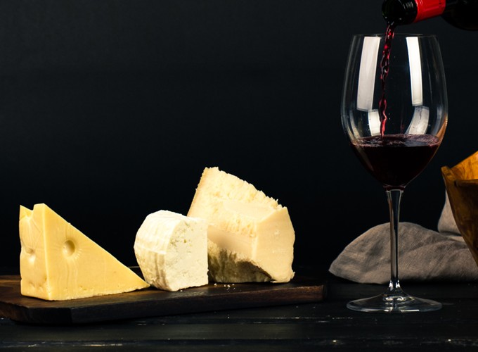 Zu Käseauswahl wird passender Rotwein eingeschenkt