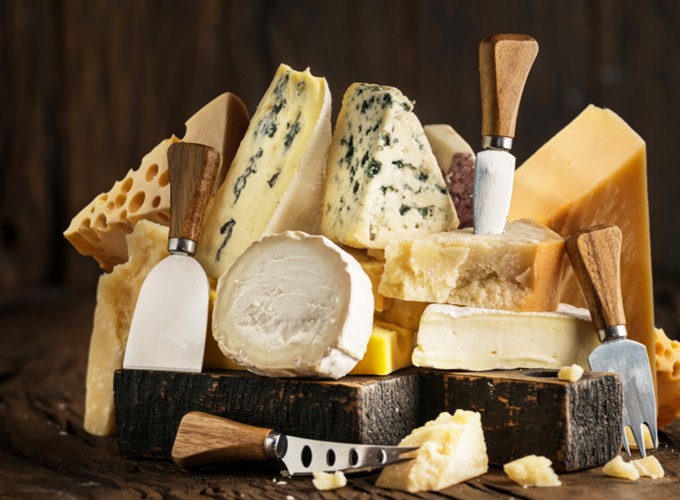 Viele Käsesorten auf Holzbrett zum Kombinieren mit feinen Übersee-Weinen